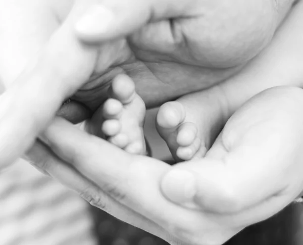 Pies de bebé y manos de hombre — Foto de Stock