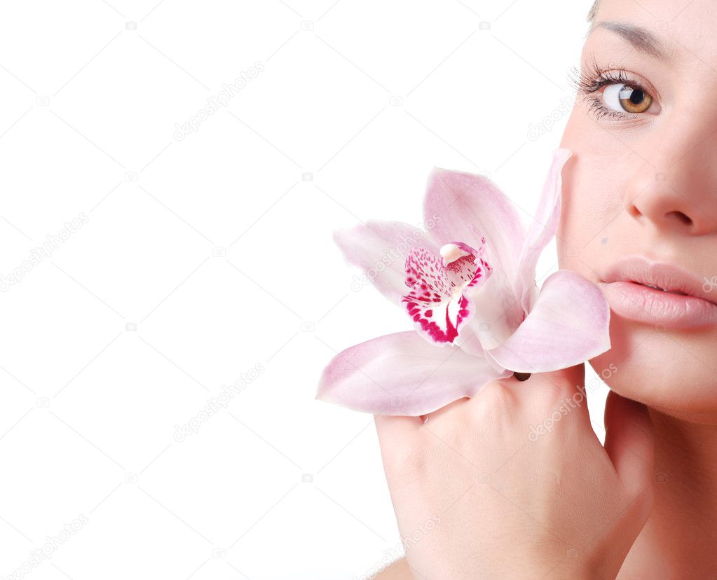 Face of beautiful young woman with delicate orchid