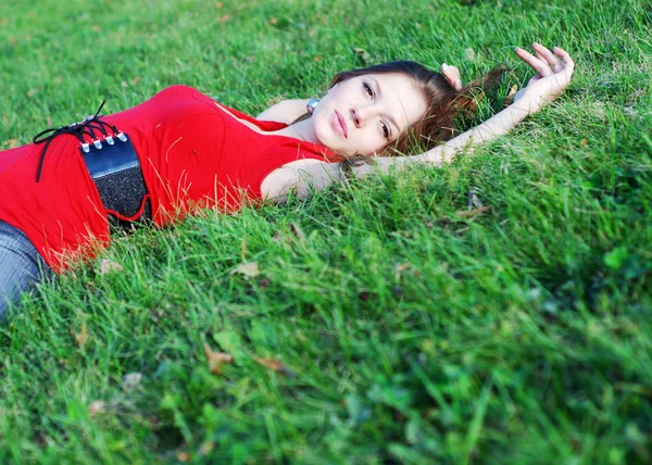 Ung kvinna och grönt gräs — Stockfoto