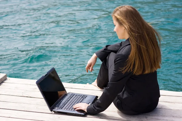 Vrouw met laptop en zee — Stockfoto