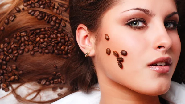 Kvinnans ansikte med kaffebönor — Stockfoto
