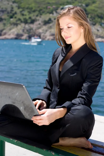 Женщина с ноутбуком у моря — стоковое фото