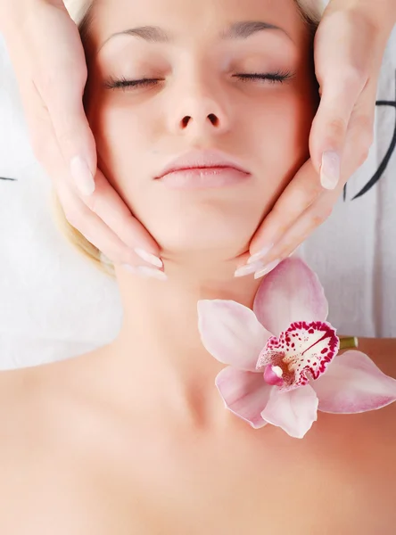 Face of beautiful young woman with delicate orchid — Stock Photo, Image