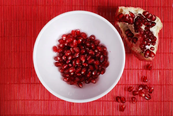 Semințe roșii și castron alb — Fotografie, imagine de stoc