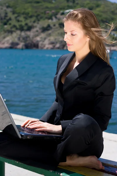 笔记本电脑在海边的女人 — 图库照片