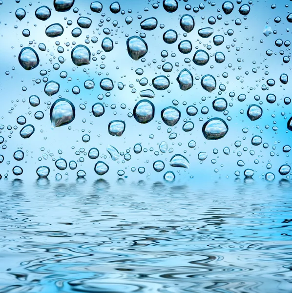 Modré kapky odráží ve vodě — Stock fotografie