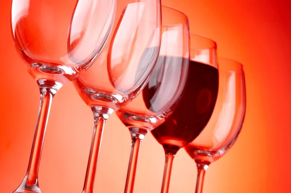Şarap, kırmızı zemin üzerine gözlük — Stok fotoğraf