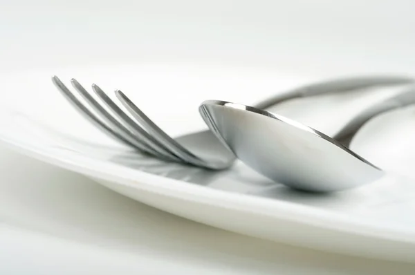 Foto de tenedor y cuchara en el plato —  Fotos de Stock