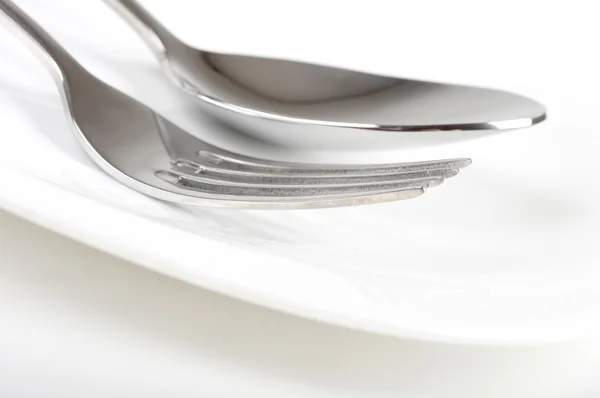 Foto de tenedor y cuchara en el plato — Foto de Stock