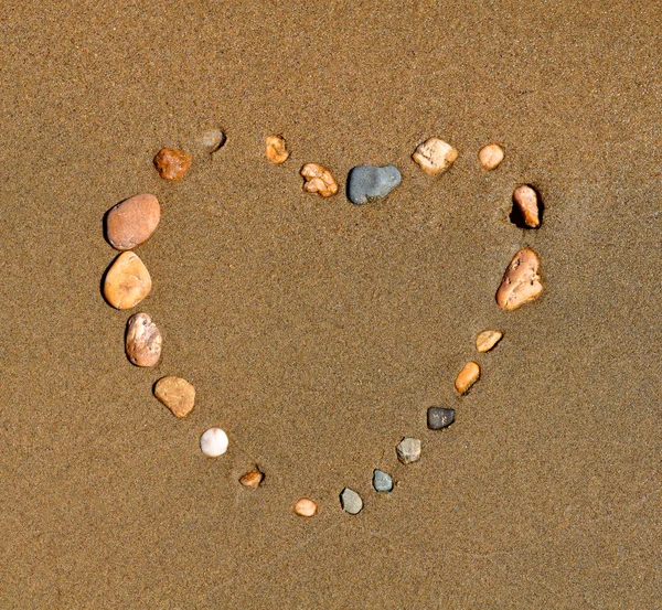 stock image Heart from a pebble on sand