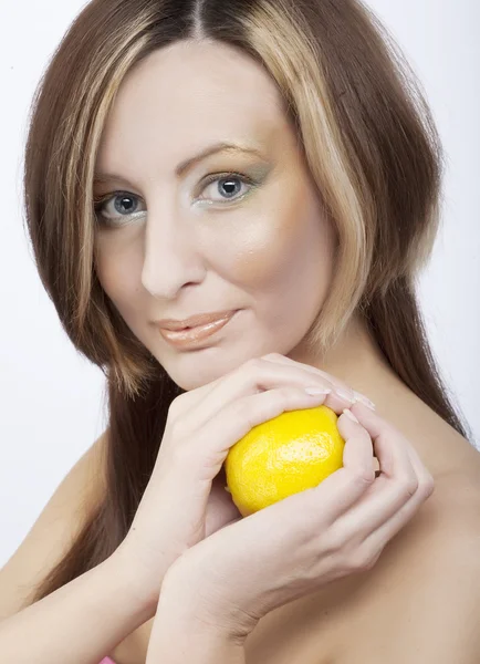 Mujer joven sosteniendo un limón — Foto de Stock