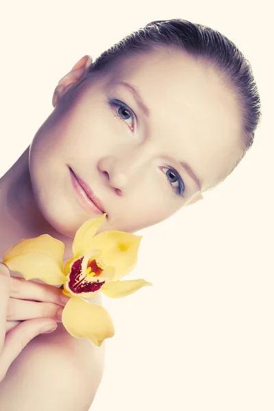 Mladá žena s žlutou orchidej — Stock fotografie