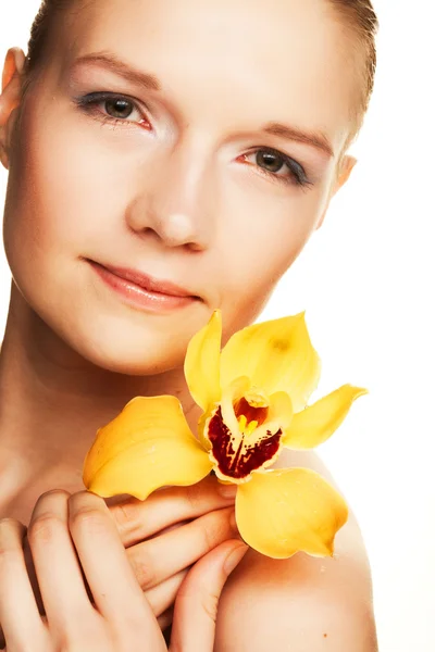 Jonge vrouw met gele orchidee — Stockfoto