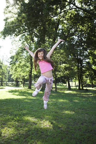 Little girl jumping in park — Stock Photo, Image