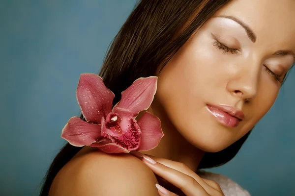 Женщина с цветком орхидеи — стоковое фото