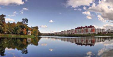 Panorama bir gölet, şehir ve sonbahar