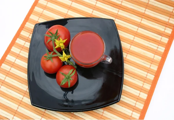 Černá deska s červenými rajčátky — Stock fotografie