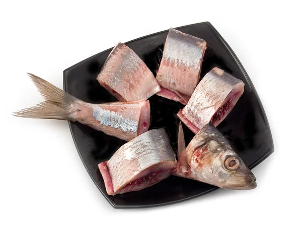 Herring pieces on black plate — Stock Photo, Image
