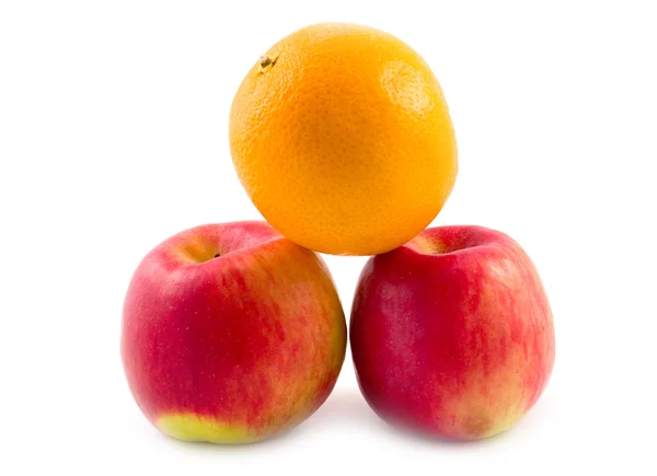 Апельсин на красных яблоках — стоковое фото