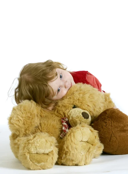 Маленькая девочка обнимает плюшевые игрушки — стоковое фото