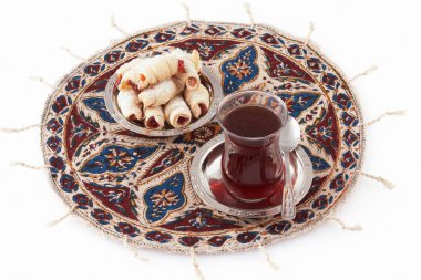 Tea and cookies served on the qalamkar clipart