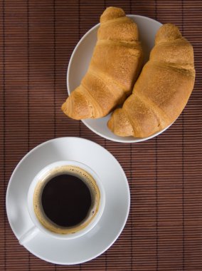 Cup of black coffee with croissants