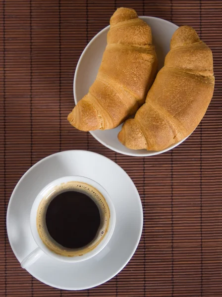 Taza de café negro con croissants — Foto de Stock