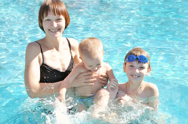 Madre con sus hijos en la piscina — Foto de Stock