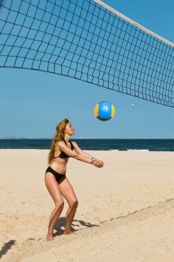 Kadınlar plaj voleybolunda oynuyor.