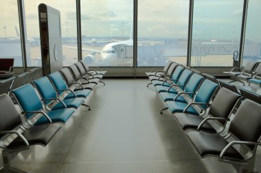 Empty armchairs at the airport and plane clipart