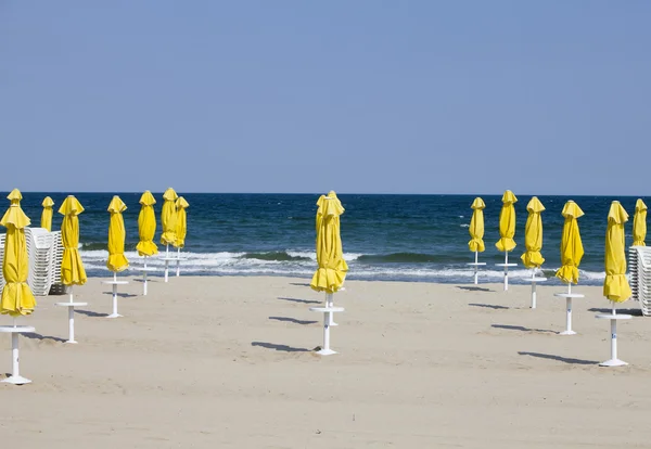 Пустынный пляж и пляжные зонтики — стоковое фото