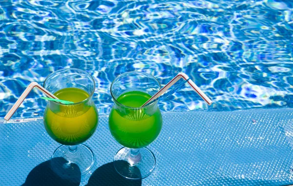 Gafas con cóctel en el borde de la piscina — Foto de Stock