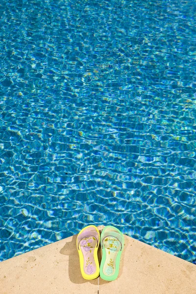 Chinelos jaz à beira da piscina — Fotografia de Stock