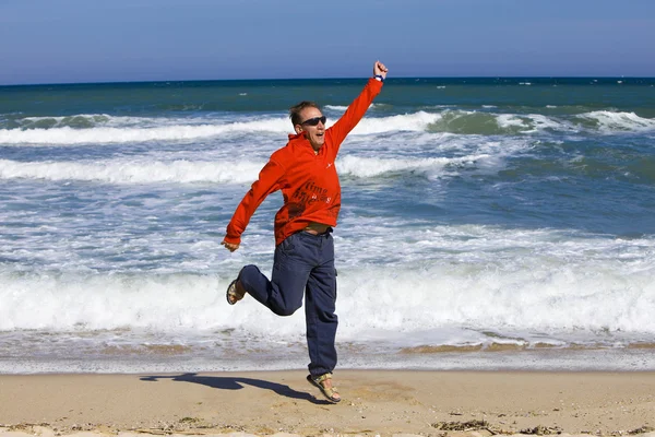 Man jumps on sand on seashore — Stock Photo, Image