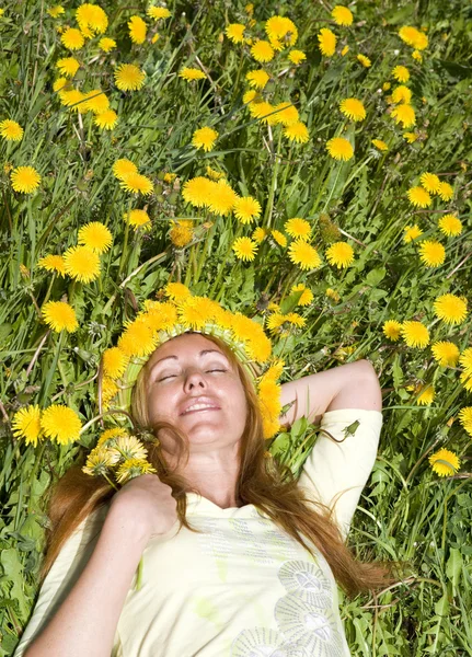 Woman has a rest in wreath of dandelions — Stock Photo, Image