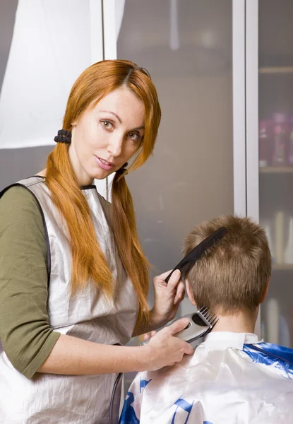 きれいな女性の美容師は、クライアントをカット — ストック写真