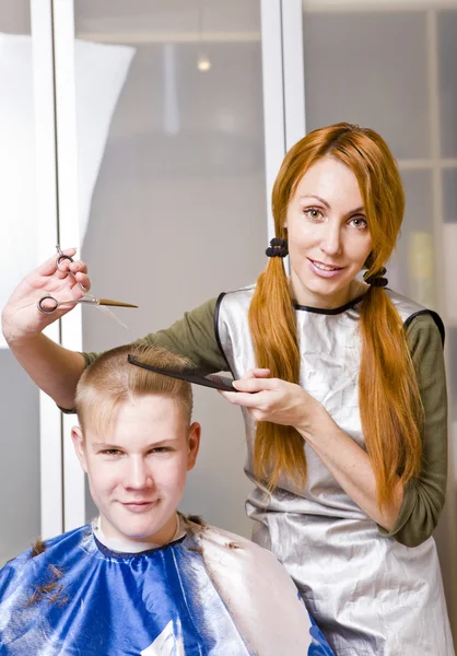 Pretty woman hairdresser cuts client — Stock Photo, Image