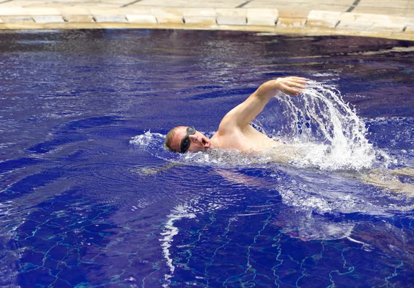 Der junge Sportler schwimmt im Pool — Stockfoto