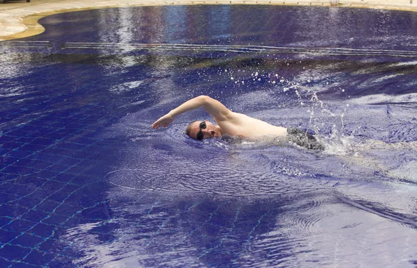 O jovem desportista flutua na piscina — Fotografia de Stock