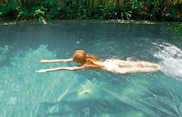 Joven hermosa mujer flota en la piscina — Foto de Stock
