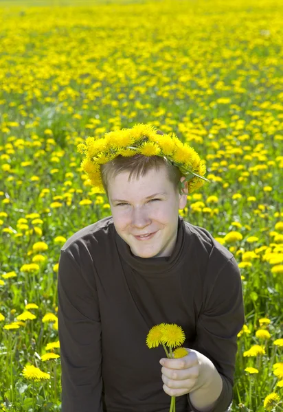 Boy teenager in wreath of dandelions — Stock Photo, Image