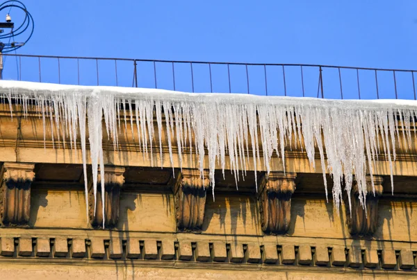 Çatıdan aşağı büyük buz sarkıtları asmak — Stok fotoğraf