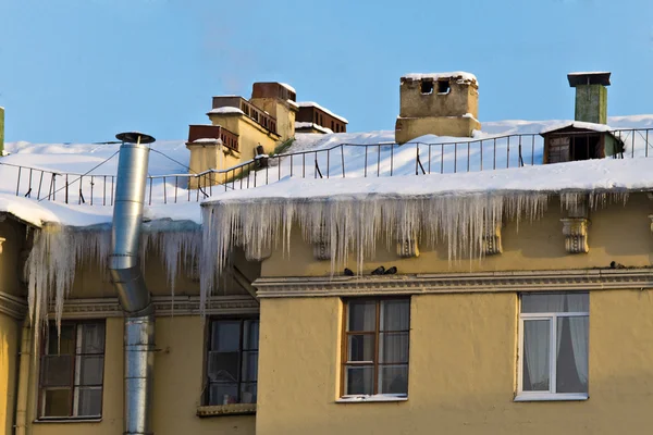 Huge icicles hang down from roof — Stock Photo, Image
