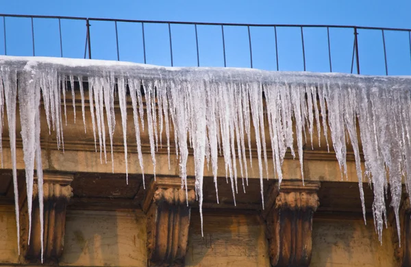 Huge icicles hang down from roof — Stock Photo, Image