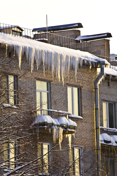 Çatıdan aşağı büyük buz sarkıtları asmak — Stok fotoğraf