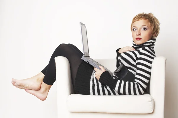 Blondgirl sitting on chair with laptop — Stock Photo, Image
