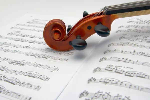 Rolagem de violino descansando em uma partitura — Fotografia de Stock