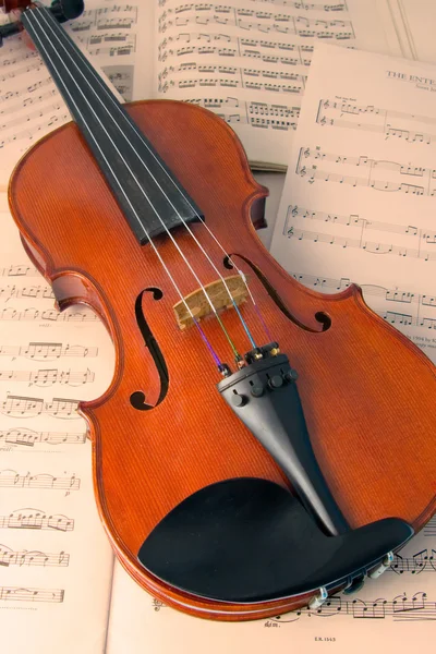 Violino descansando em partituras musicais — Fotografia de Stock