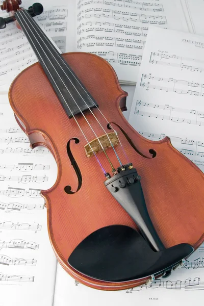 Violino descansando em partituras musicais — Fotografia de Stock