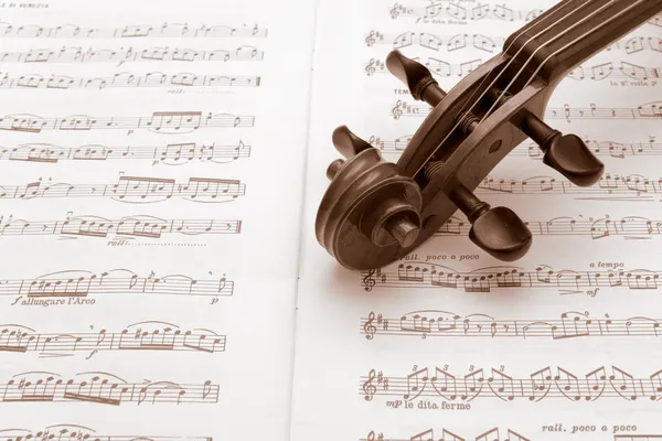 Винтажная скрипичная шея поверх нот — стоковое фото